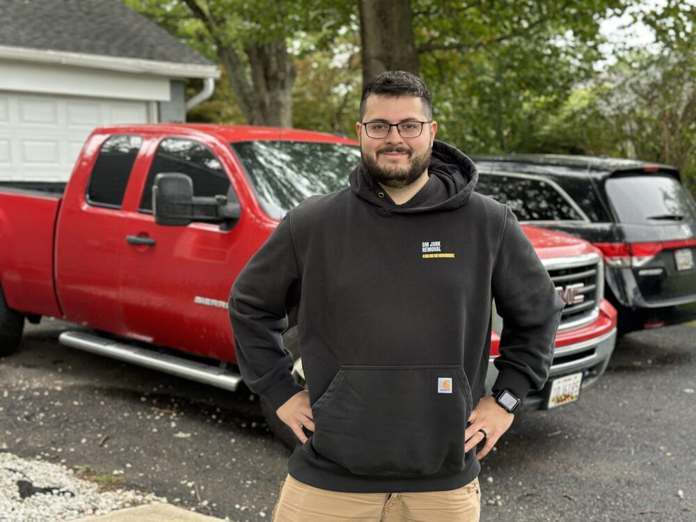 gm junk removal expert standing in front of truck